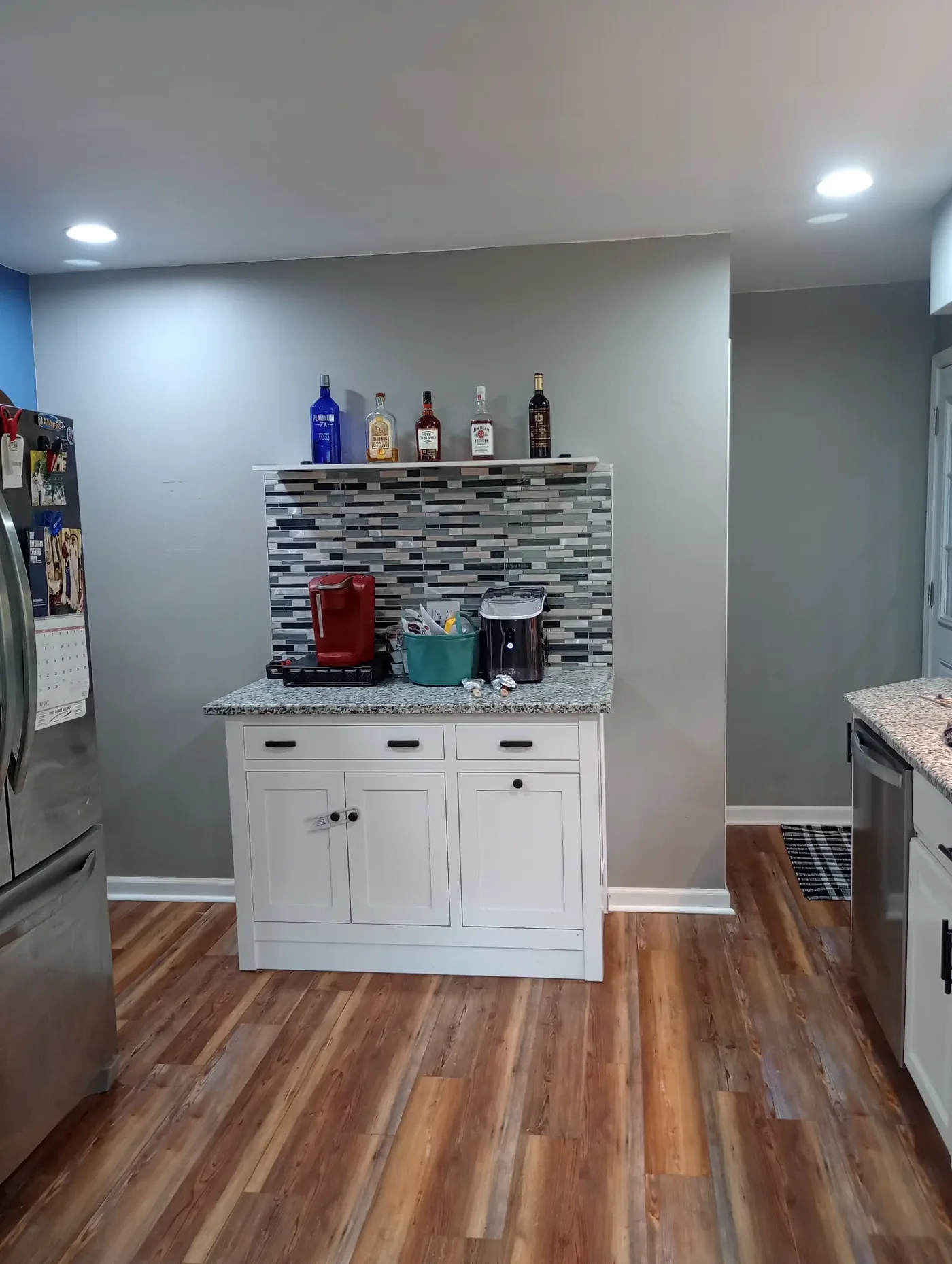 Kitchen coffee and bar station with mosaic tile backsplash, granite countertop and white shaker cabinets