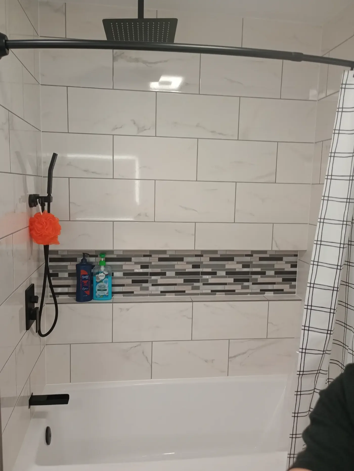 Walk-in shower with marble-look tile surround, built-in niche and rain showerhead