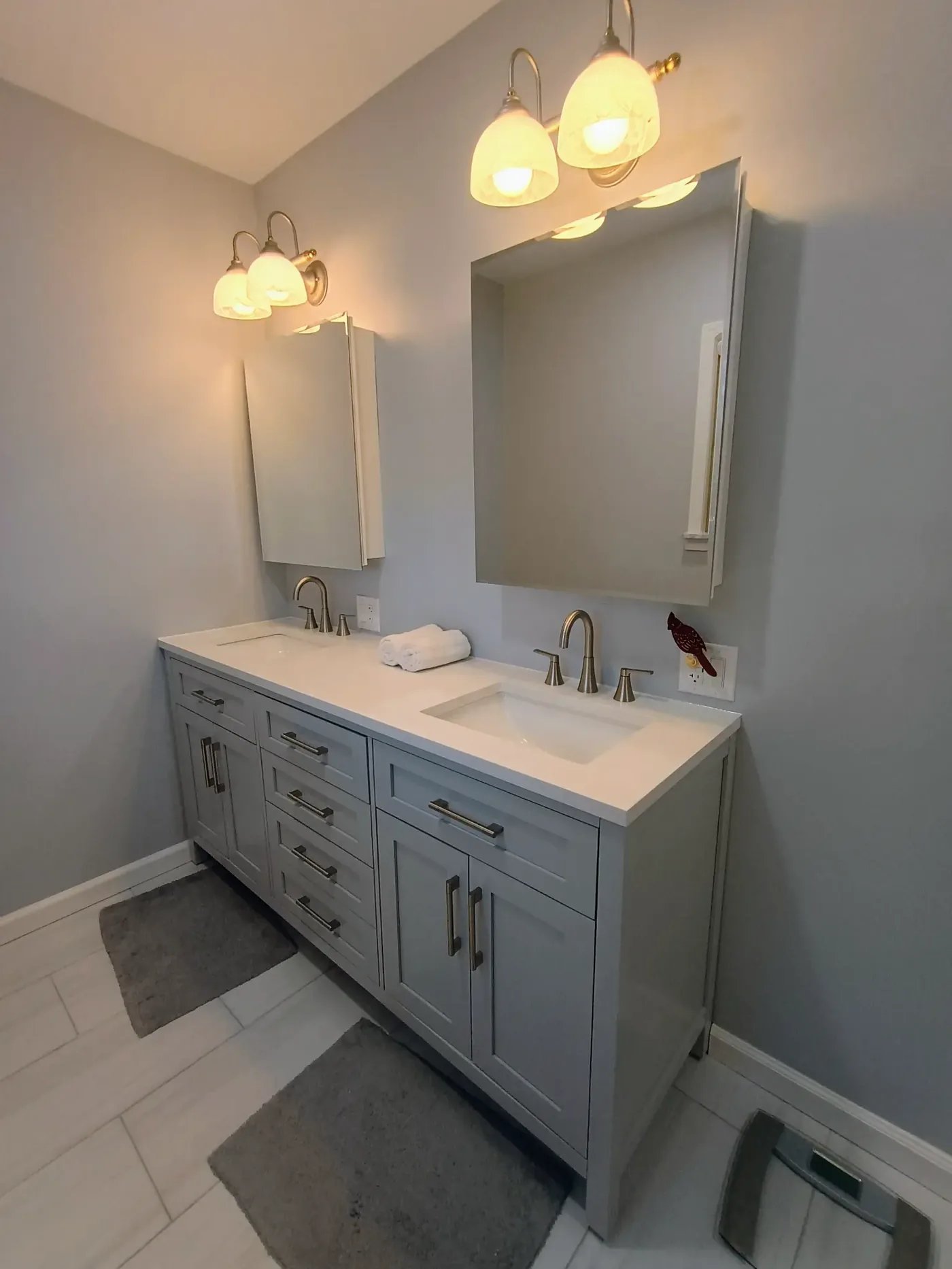 Bathroom double vanity with gray shaker cabinets, white quartz countertop and dual undermount sinks